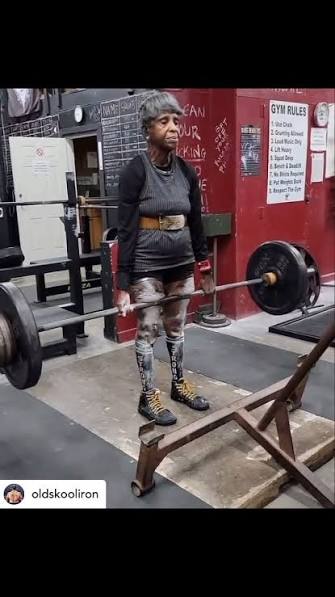 Lifter locking out a heavy deadlift in a gym