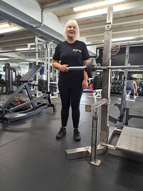 Lifter loading a barbell in a commercial gym